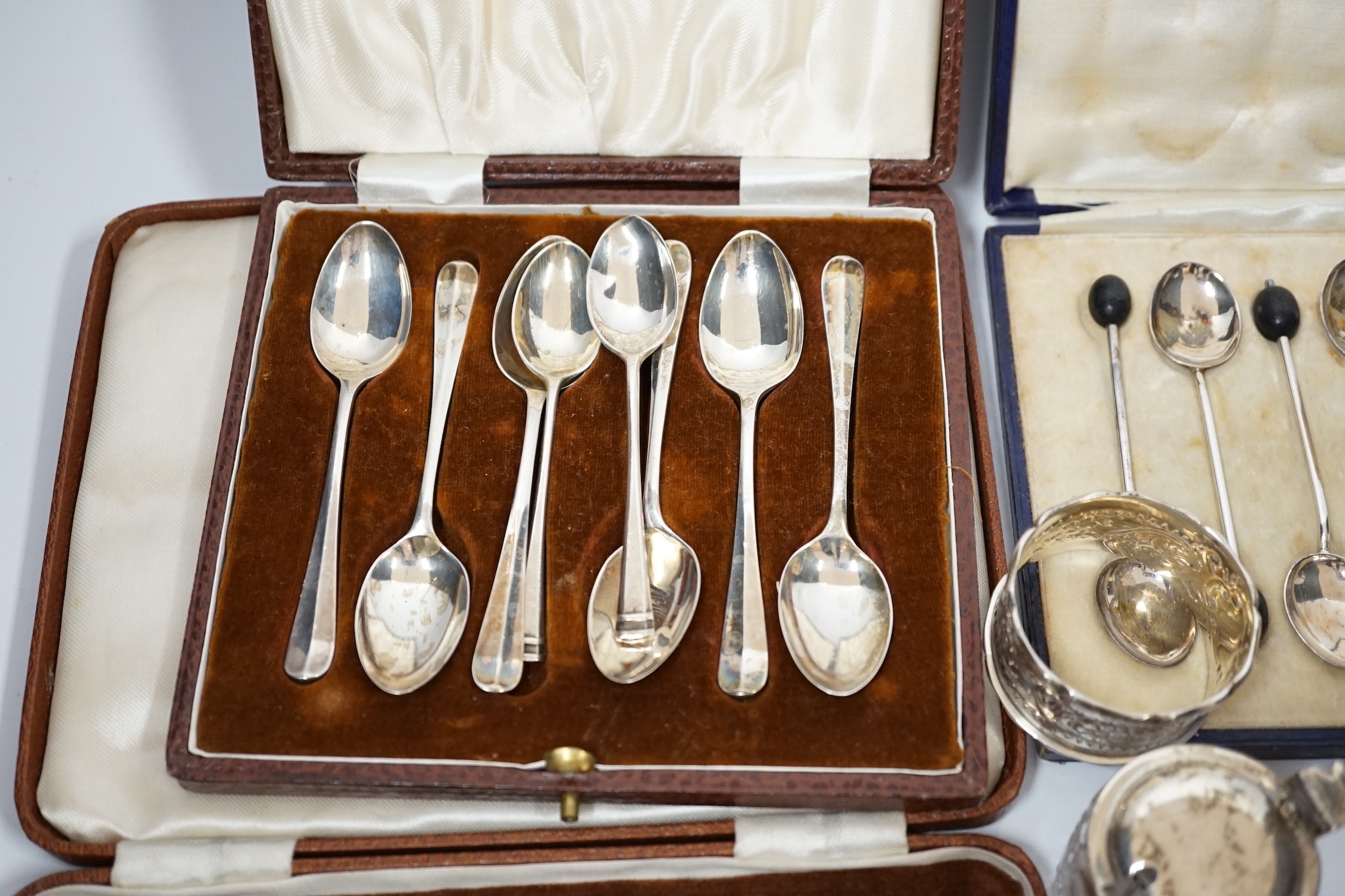 A white metal pepperette modelled as barrel and other silver and plated items including a Georgian caddy spoon, condiments, three cased sets of silver spoons, etc.